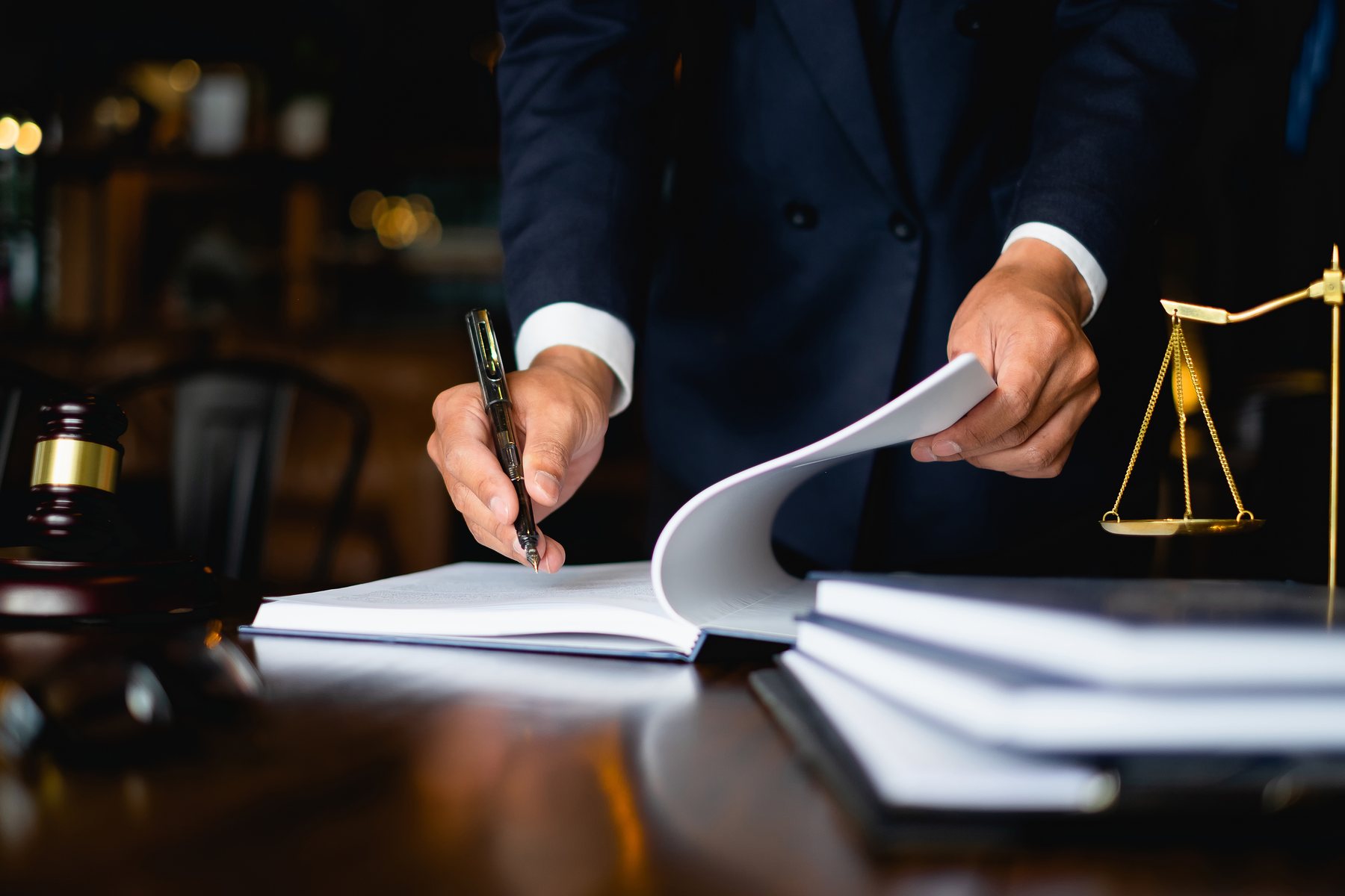 Close up lawyer businessman working or reading lawbook in office workplace for consultant lawyer concept. Adobe Stock 203206616.